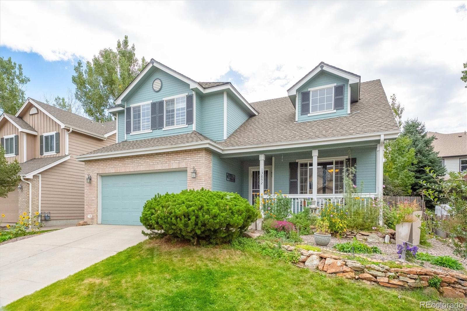 Front of 13852 W 64th Pl, a blue two-story home