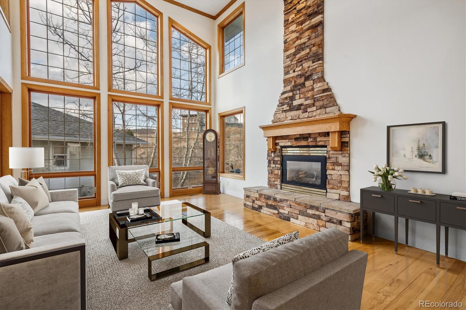 Living room with two-story windows and a stone fireplace